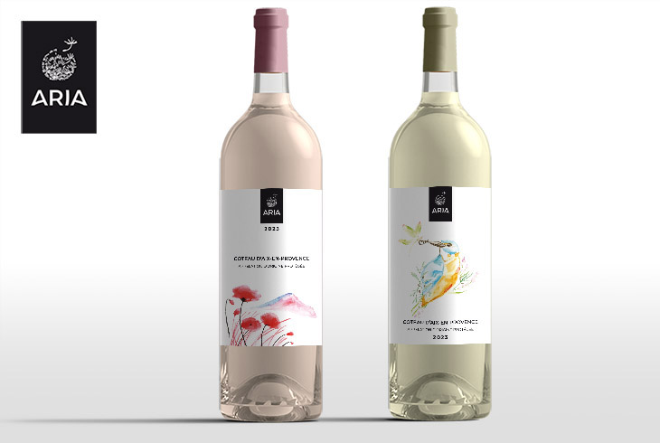 Deux bouteilles de vin ARIA, cuvées 2023, côteaux d’Aix-en-Provence : à gauche, un rosé avec une étiquette illustrée de coquelicots ; à droite, un blanc avec une étiquette illustrée d’un martin-pêcheur à l’aquarelle.