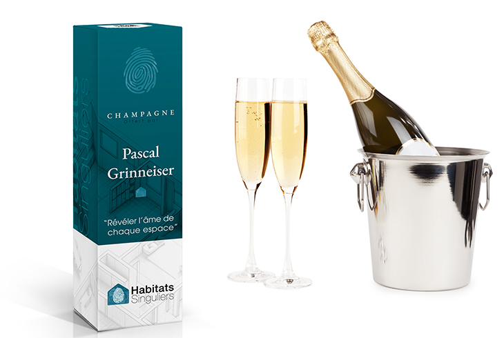 Coffret de champagne personnalisé pour Habitats Singuliers, conçu par Zébra design, avec deux flûtes et un seau à champagne.